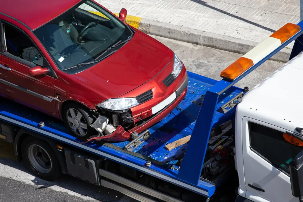A crashed car loaded on a tow truck.